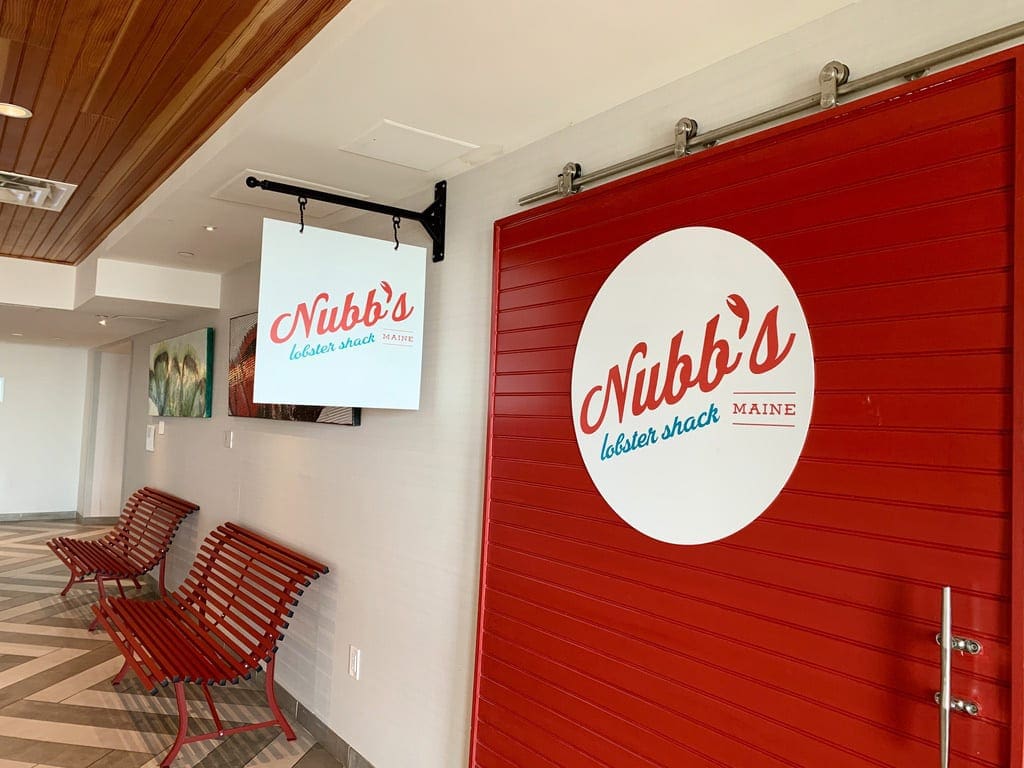 Red door with a sign saying Nubb's Lobsert Shack, one of the restaurants on-site at Cliff House Maine.