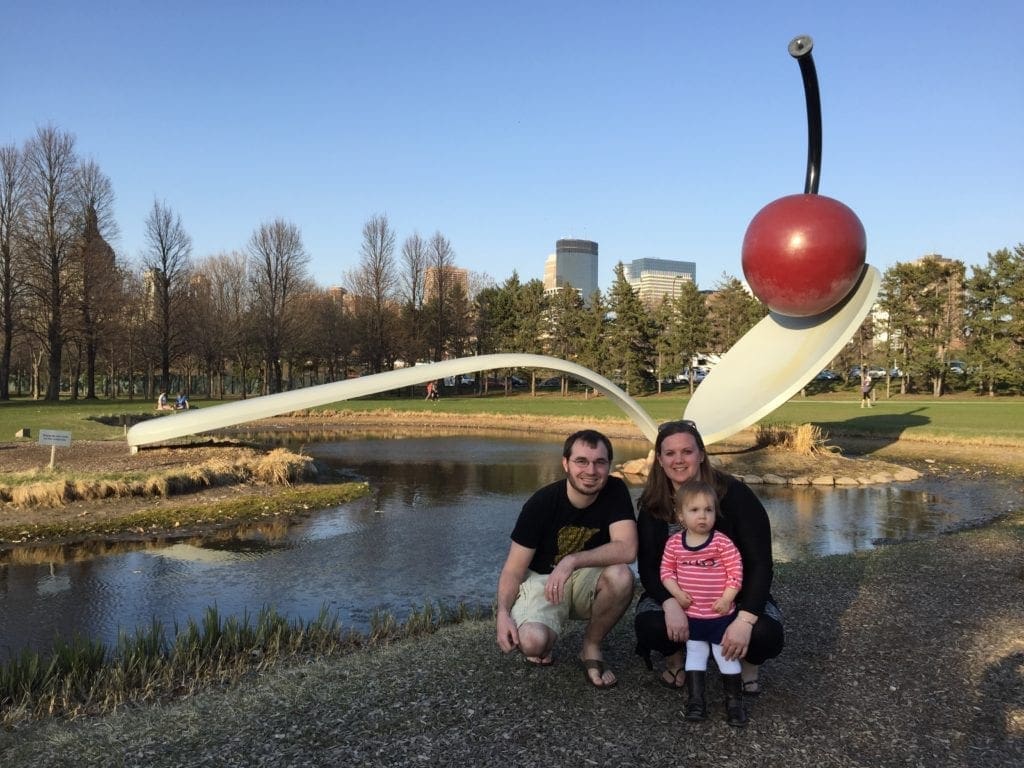Antonia Grant and her family poses at the Minneapolis Spoon & Cherry sculpture, one of the best free things to do in Minneapolis with kids.