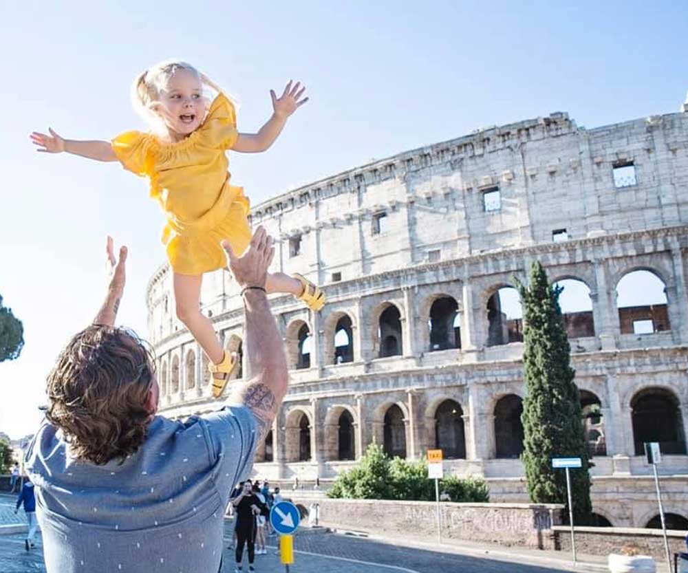 Father throwing girl in the air in Rome Italy