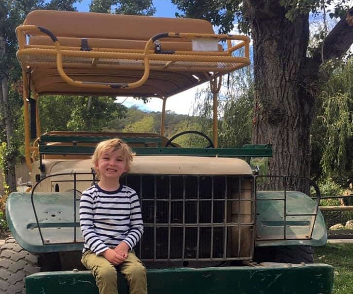 Boy sitting on a safari van in Safari West Sonoma on of the best west coast safari parks.
