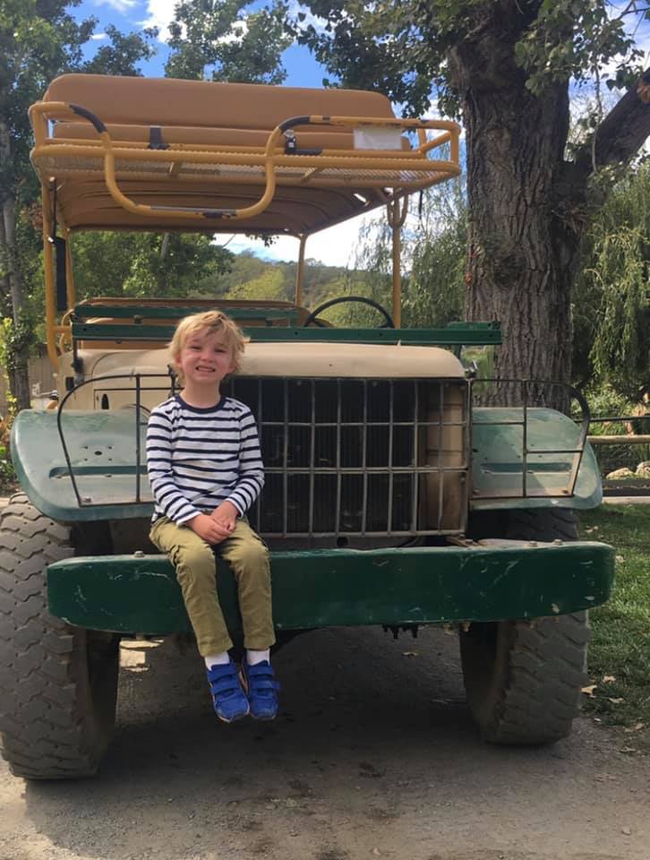Boy sitting on a safari van in Safari West Sonoma on of the best west coast safari parks