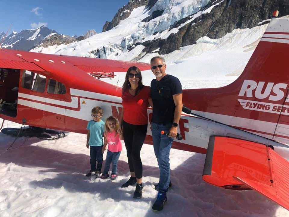 Family in front on a plane in Denali National Park, one of the best national parks for families.