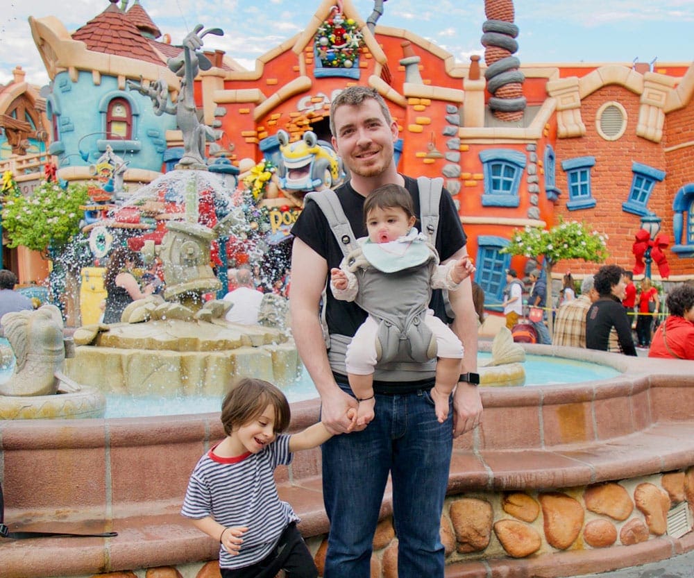 Father with toddler and baby in carrier at Disneyland