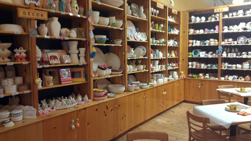 Inside Color Me Mine, featuring shelves filled with ceramics ready for fun family-friendly classes. 