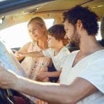 Mom, dad and little boy in the car looking at a map. family road trip games