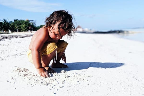 Cancun Vacation Kids, Little boy on beach playing in the sand in Cancun Vacation Families