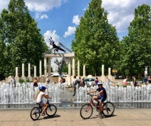 kids on bikes in front of water fountains Madrid