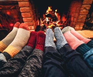 Family feet in socks in front of a fireplace in Aspen