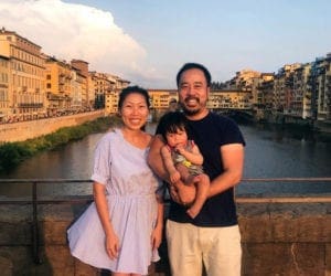 Family with a baby in front of water in Florence Italy