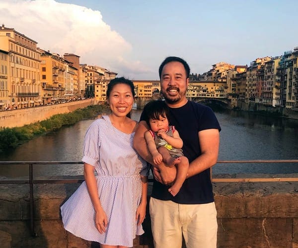 Family with a baby in front of water in Florence Italy