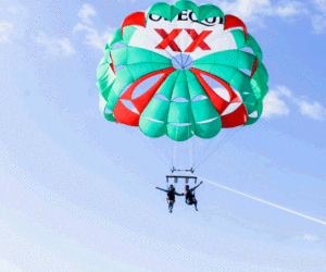 Two people go parasailing in Mexico.