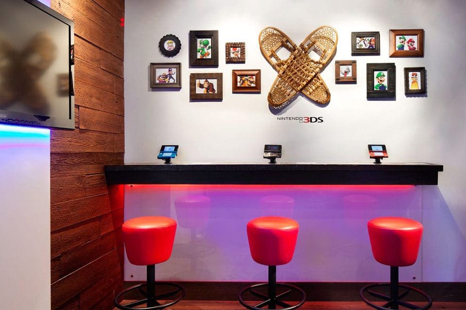 Three red stools inside Nintendo® Gaming Lounges.