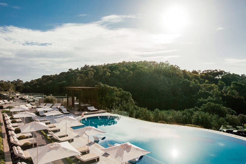 The outdoor pool with poolside loungers on a sunny day at Penha Longa Resort.
