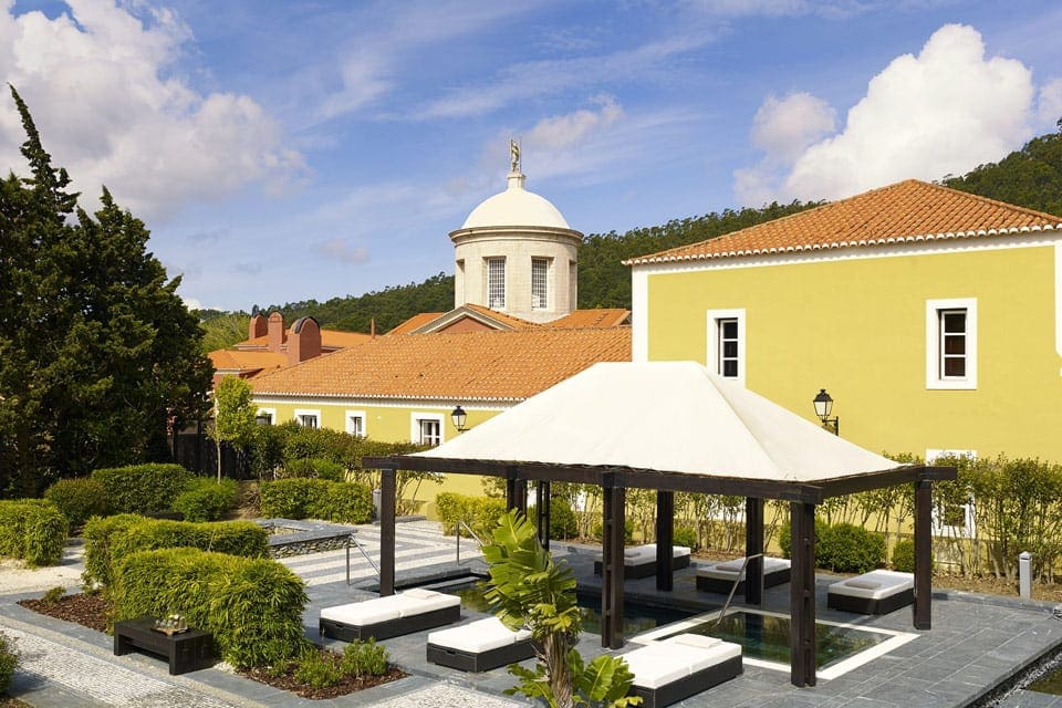 An outdoor view of the iconic yellow buildings at the Penha Longa Resort, one of the best places to stay in Lisbon with kids. 