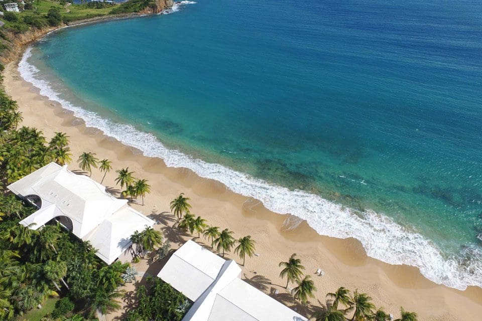 An aerial view of Curtain Bluff, featuring golden sands and turquoise waters at one of the best all-inclusive resorts in the Caribbean for families.