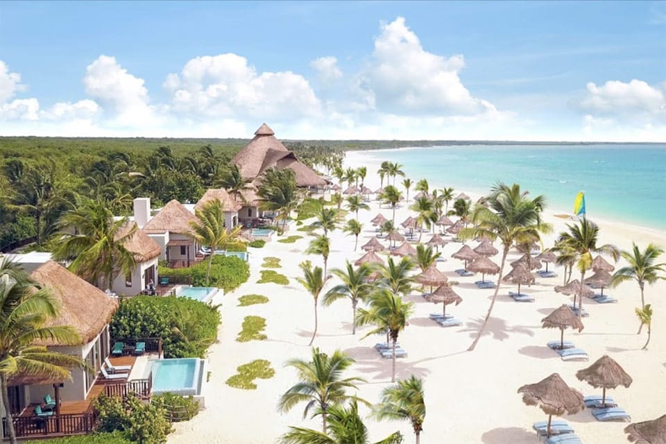 Beautiful beach with villas, palm trees at Fairmont Mayakoba, one of the best all-inclusive resorts Playa del Carmen for families.