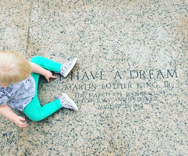 A small boy sits above the text "I Have a Dream" etched in marble.