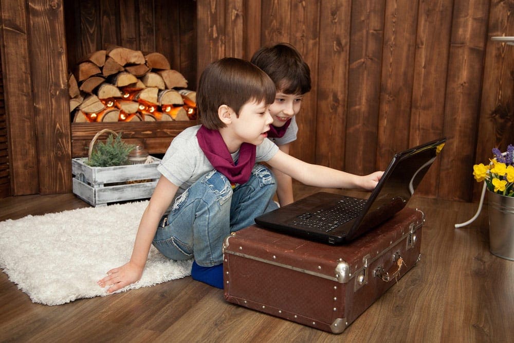 Two boys watch a video on a laptop. Movies are a great way to explore a new country, especially on your virtual vacation to Norway.