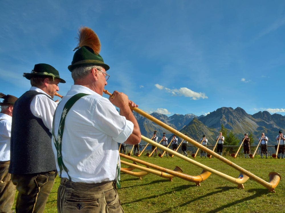 Men playing alphorn. Listening to music is a great way to take a virtual vacation to Lucerne.