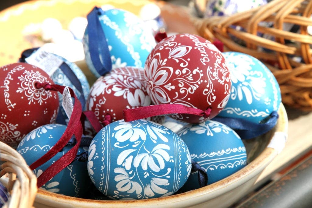 A basket of Hungarian Easter eggs colored in blue or red with white designs. Hungary is our first stop as we explore Easter around the world.
