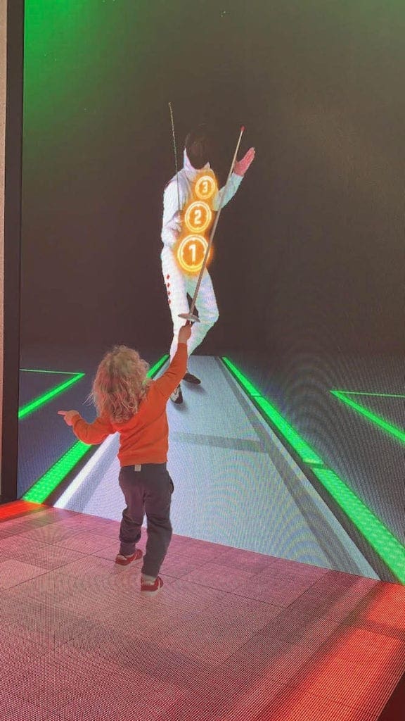 A young child pretends to fence at an interactive exhibit at the Interactive Museum in Montreal.