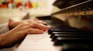 Hands playing a piano. Music is the perfect way to enjoy a Virtual Vacation from Home to Amsterdam.