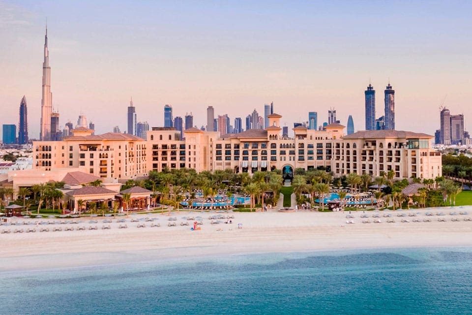 The expansive beachfront property and resort buildings of the Four Seasons Resort Dubai at Jumeirah Beach at sunset.