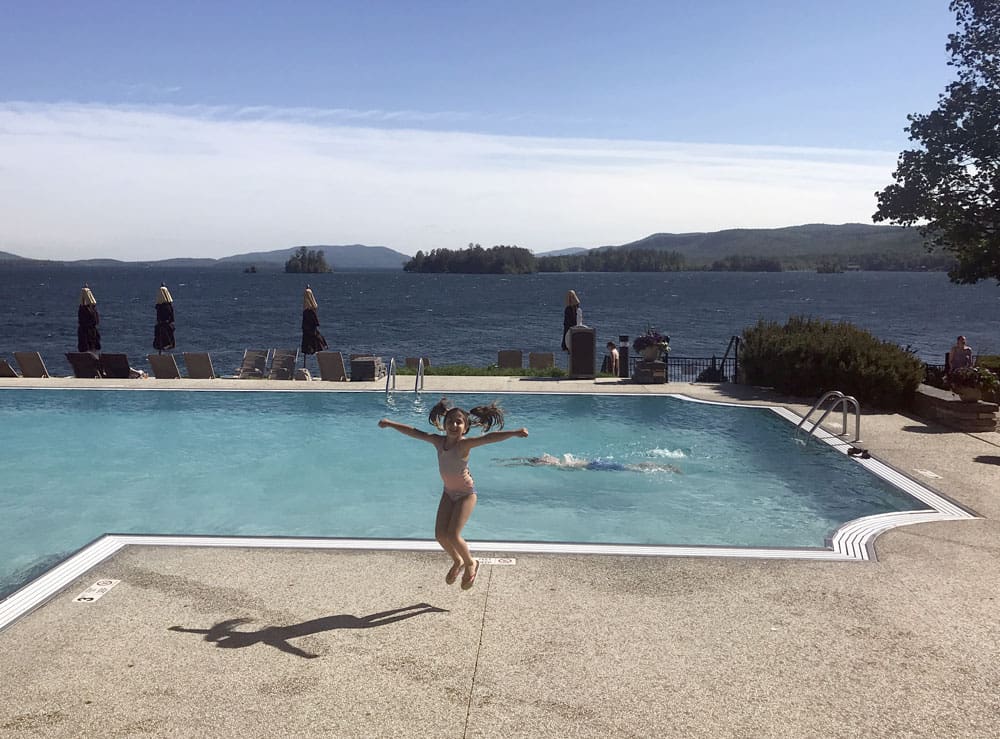 Girl jumping near the pool at Sagamore hotel at Lake George.