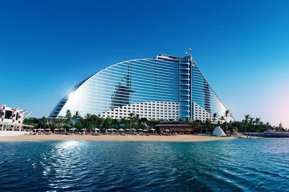 View of the Jumeirah Beach Hotel in Dubai, one of the best family hotels in Dubai, which looks like a dorsel fin extending from the beach.