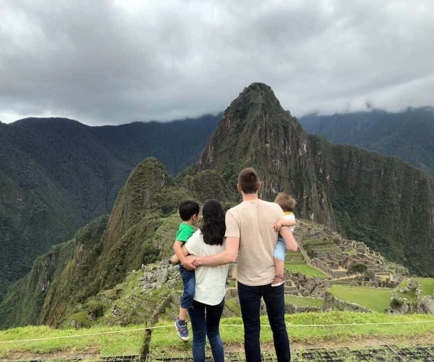 Family of four admiring the view at top of the mountain in Macchu Picchu, Peru