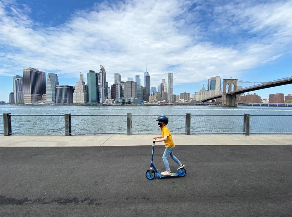Boy riding a scooter around the Hudson River, one of the stops as we travel to New York City.