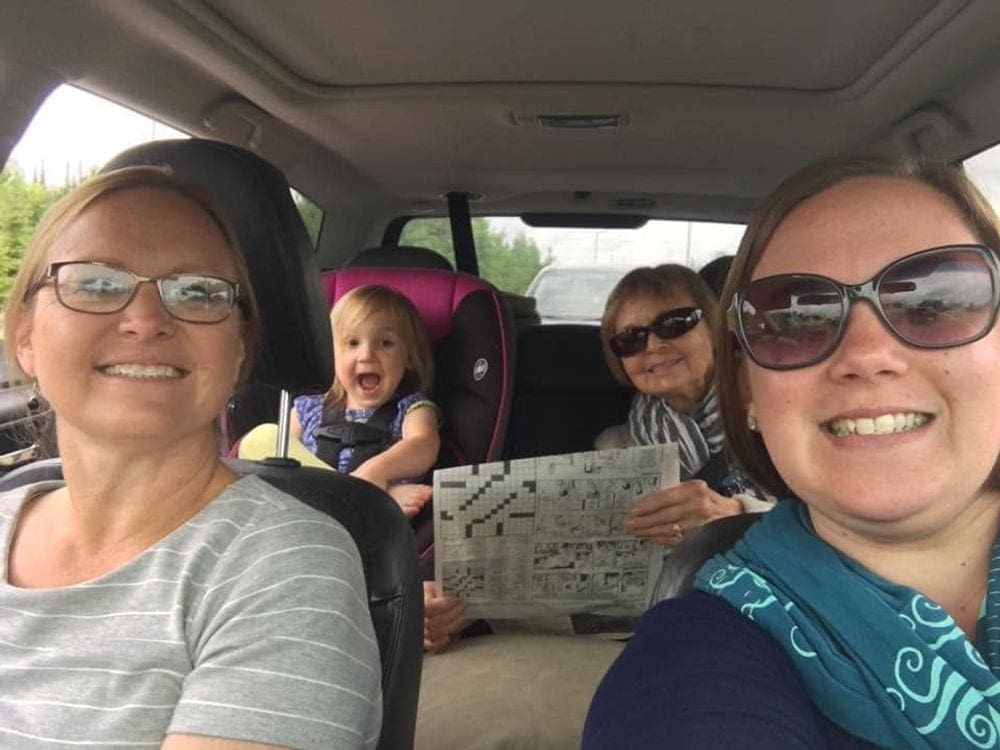 3 adults and 1 child ride in a car. Enjoying adult time while kids are distracted is perfert for staying sane on family road trips.