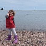 Little girl on a pebble beach of Lake Superior