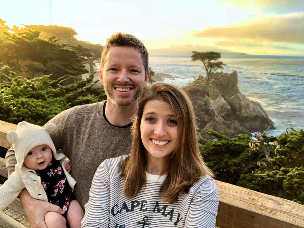 Family of three stands in front of the ocean in Big Sur.
