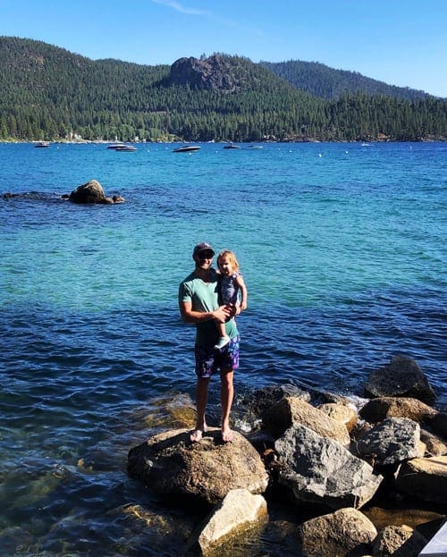 Dad holding a baby girl in his arms in Lake Tahoe