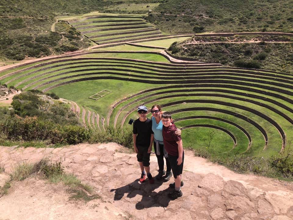 Mom and two kids stand above an ancident ruin in Moray, Peru, the second stop on our virtual vacation from home to Peru.