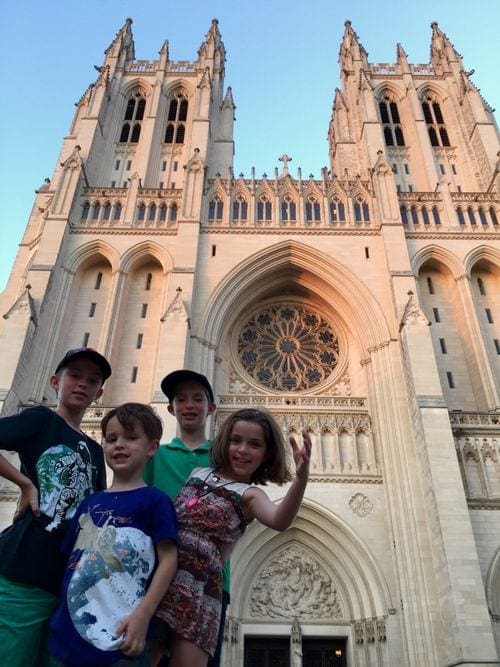 Four young kids stand in front of the National Cathedral.