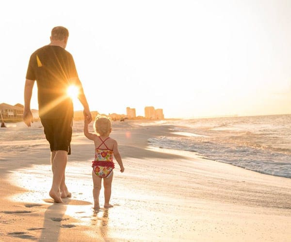 Dad and daughter walking on beach at sunset in Navarre Beach in Florida