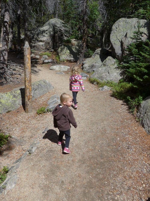 Two young children hike along a path near Denver.
