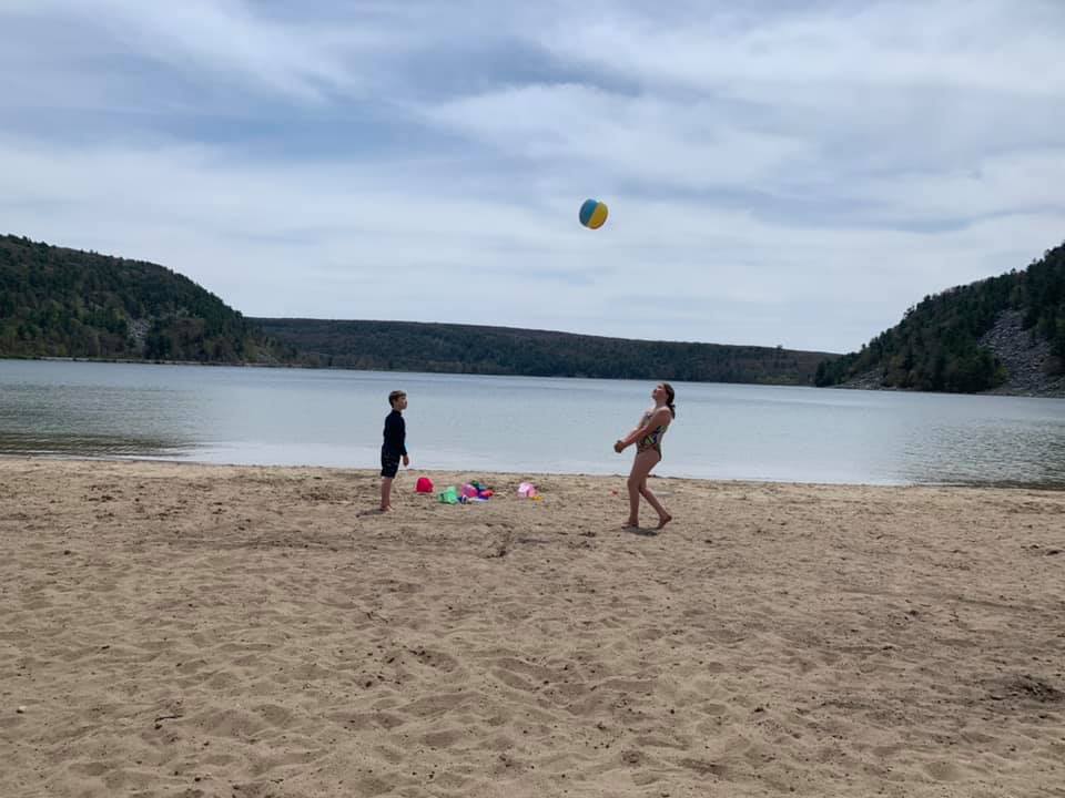 Kids playing with a ball on the Devils lake beach 
