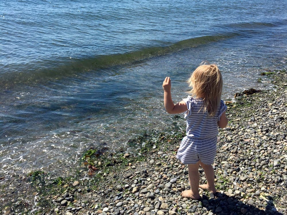 Girl throwing a rock into Puget Sound in Seattle, Washington.