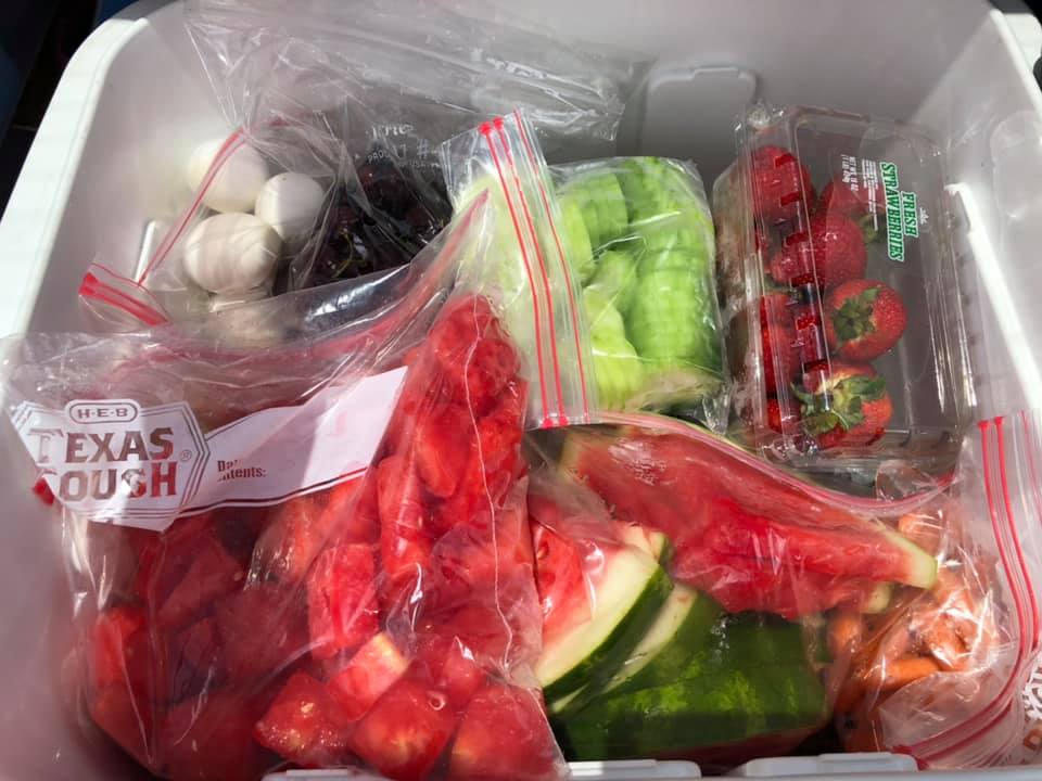 A cooler full of healthy snacks, including boiled eggs, watermelon, and boiled eggs.