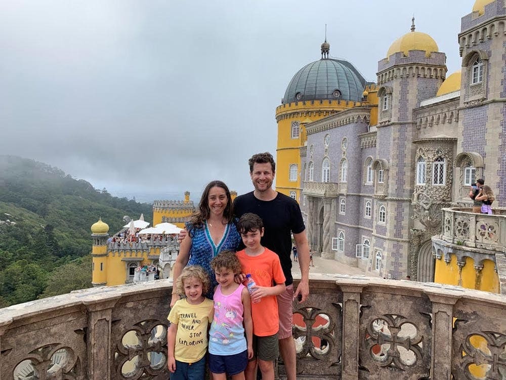 Family with three children on balcony of Pena Palace in Portugal.