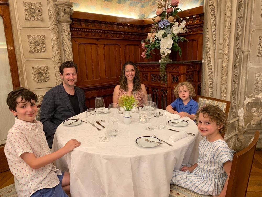 Family of five eating a formal dinner at a restaurant.
