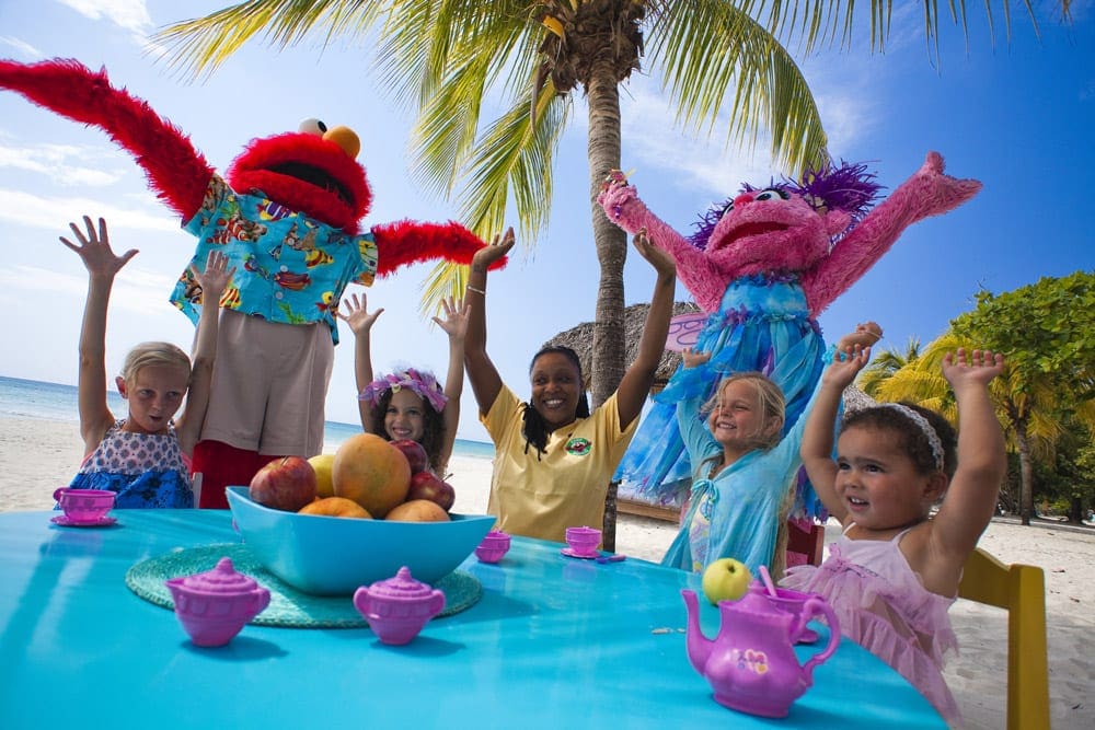 Four children, along with a staff member and two Seasame Street characters have a tea party at Beaches Negril.