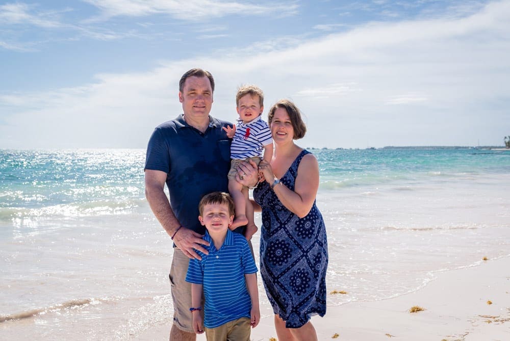 A family of four stands on the beach at The Reserve Paradisus Palma Real, one of the best Caribbean resorts with baby clubs.