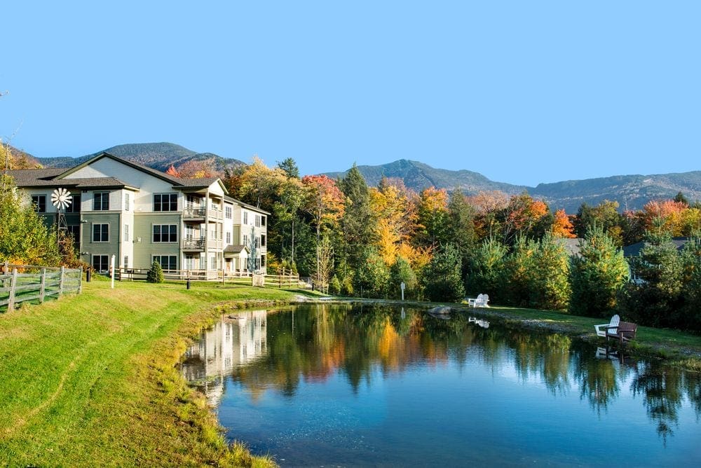 Along a pristine lakeside sits a number of buildings part of the Smugglers Notch Resort.
