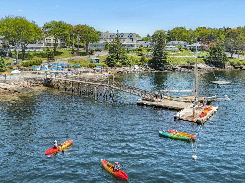 Aerial view of three kayaks off a dock at Spruce Point Inn Resort & Spa in Maine, one of the best Maine hotels for families.