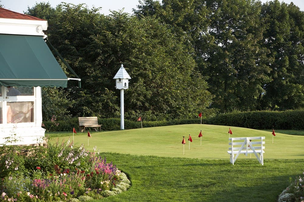 A small putting green and lovely white bird house on the lawn of The Colony Hotel, one of the best Maine hotels for families.