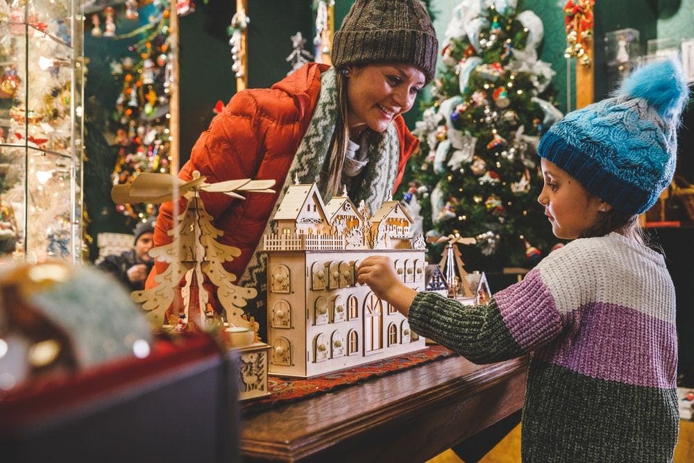 A woman leans over a Christmas display while looking at her child in Branson, Missouri, one of the most magical Christmas towns for families.